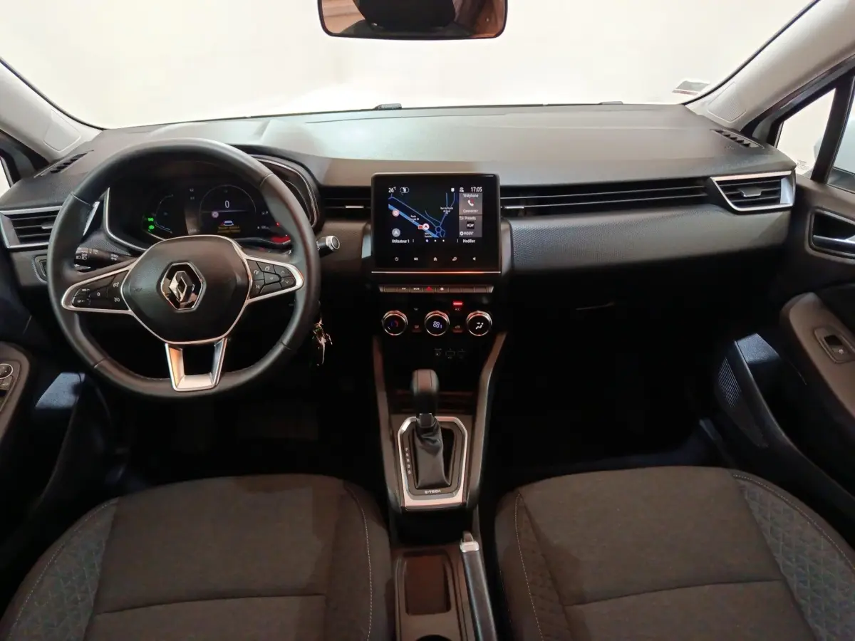 Vue intérieure avant de la Renault Clio Business E-TECH 140 2021, tableau de bord noir avec écran tactile central et volant multifonctions.