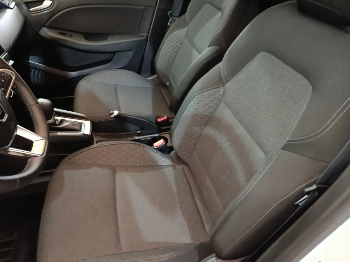 Vue intérieure rapprochée des sièges avant gris et du volant cuir synthétique de la Renault Clio Business E-TECH 140 2021.