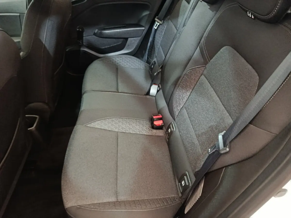 Vue intérieure côté droit sur la banquette arrière grise avec ceintures et fixations Isofix d'une Renault Clio blanche.