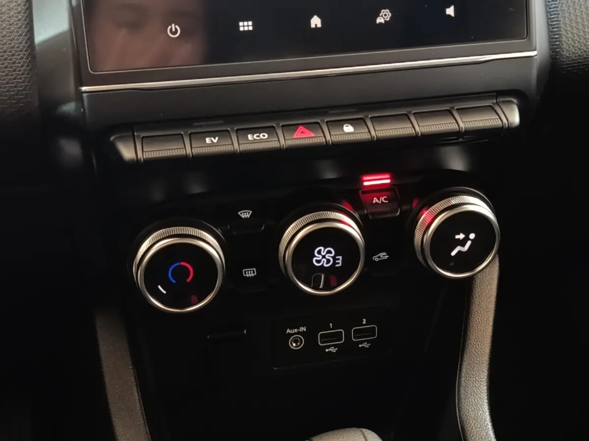 Vue rapprochée des commandes de climatisation et connectiques USB de la Renault Clio Business E-TECH blanche de 2021.