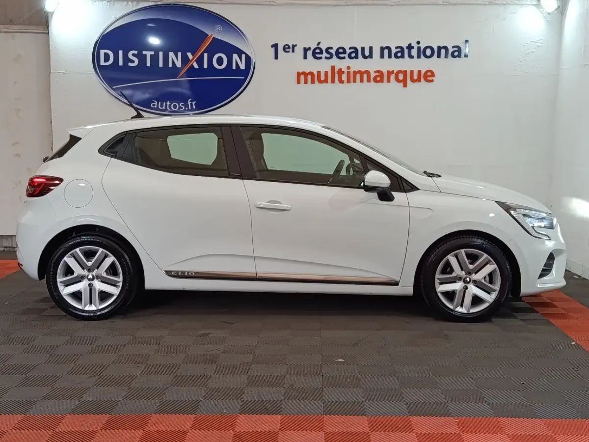 Profil droit de la Renault Clio Business E-TECH 140 blanche de 2021 avec jantes alliage et logo Clio sur la bas de caisse.