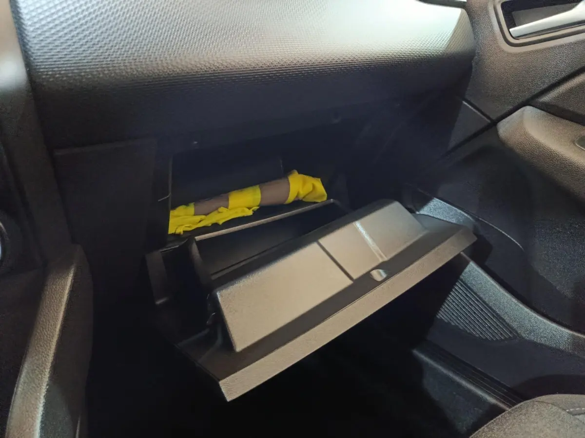 Gant de boîte à gants ouvert côté passager dans l'habitacle noir d'une Renault Clio Business E-TECH blanche 2021.