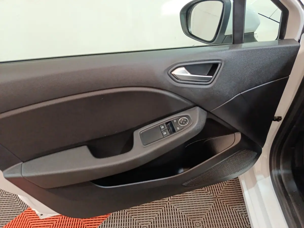 Vue intérieure de la porte avant gauche de la Renault Clio Business E-TECH 140 blanche, avec commandes de vitres et rétroviseur.