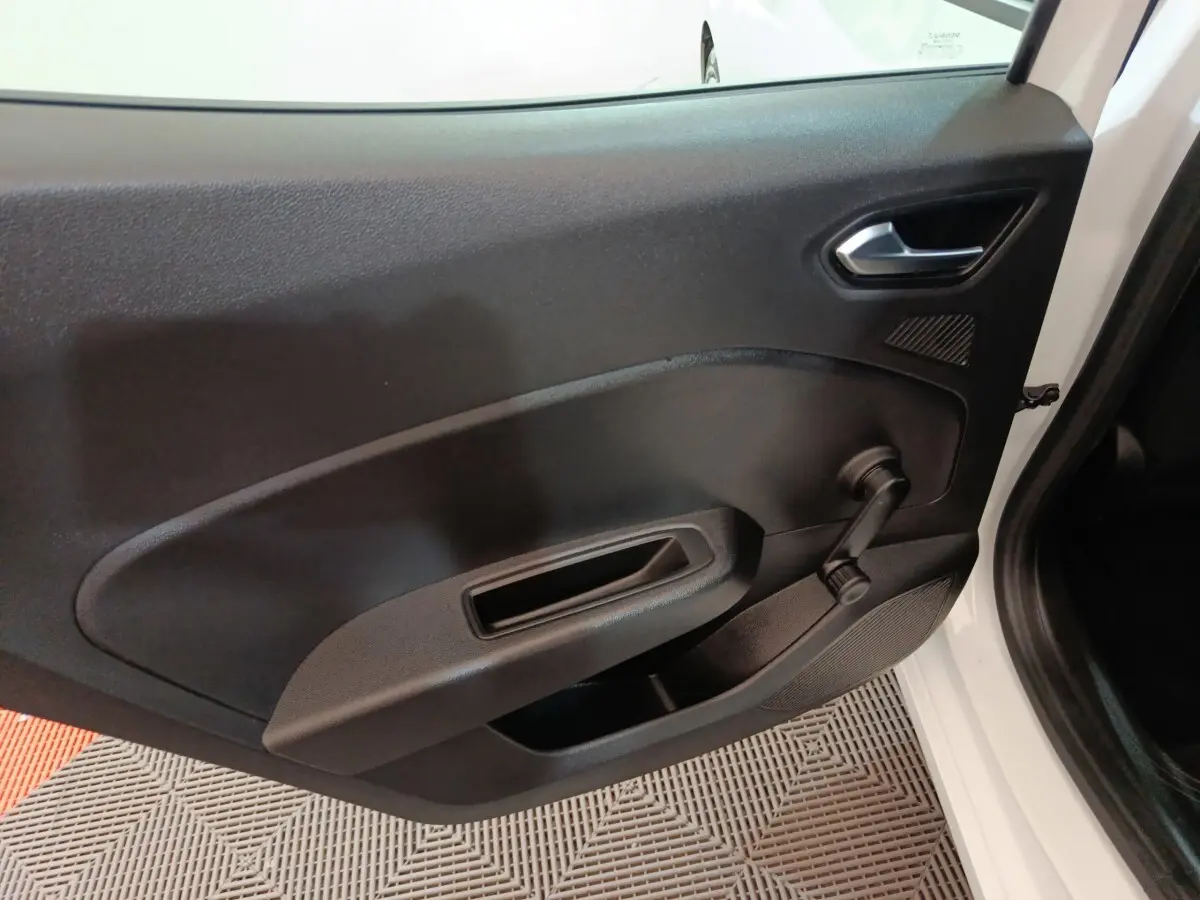 Vue intérieure de la porte avant droite noire d'une Renault Clio Business E-TECH blanche, avec manivelle de vitre visible.