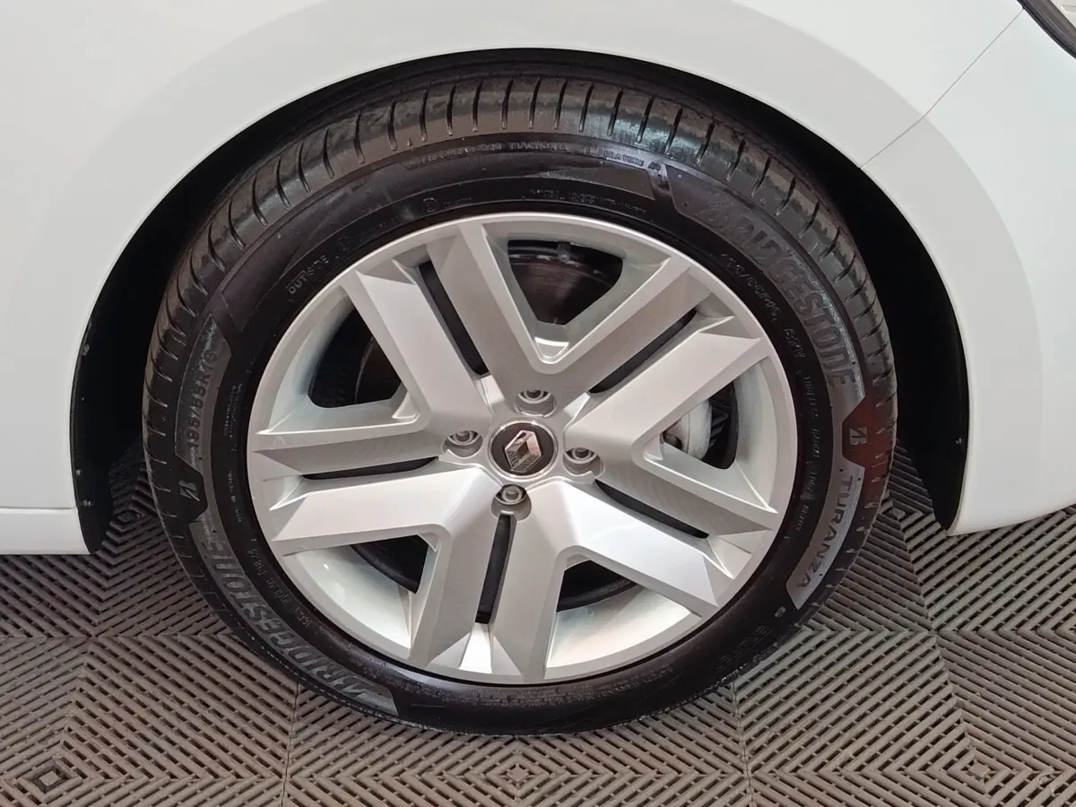 Gros plan sur la roue avant droite blanche d'une Renault Clio Business E-TECH 140 avec jante alliage et pneu Bridgestone.