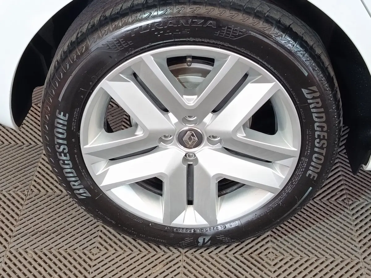 Gros plan sur la jante alliage argentée et le pneu Bridgestone d'une Renault Clio blanche.