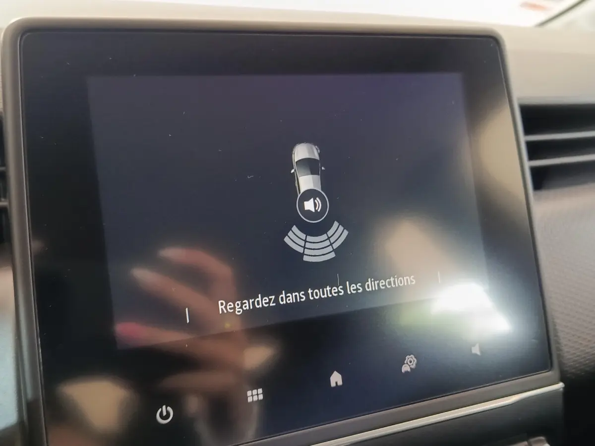 Écran tactile central de la Renault Clio Business E-TECH 140 blanc, affichant une alerte de sécurité.
