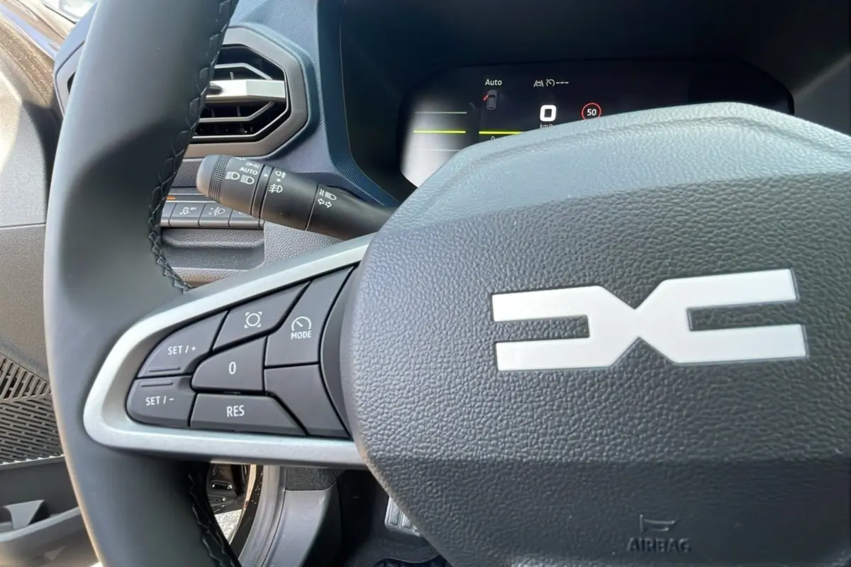Vue rapprochée du volant avec commandes intégrées du Dacia Bigster TCE 130 4x4 Expression Plus 2025 noir perle.