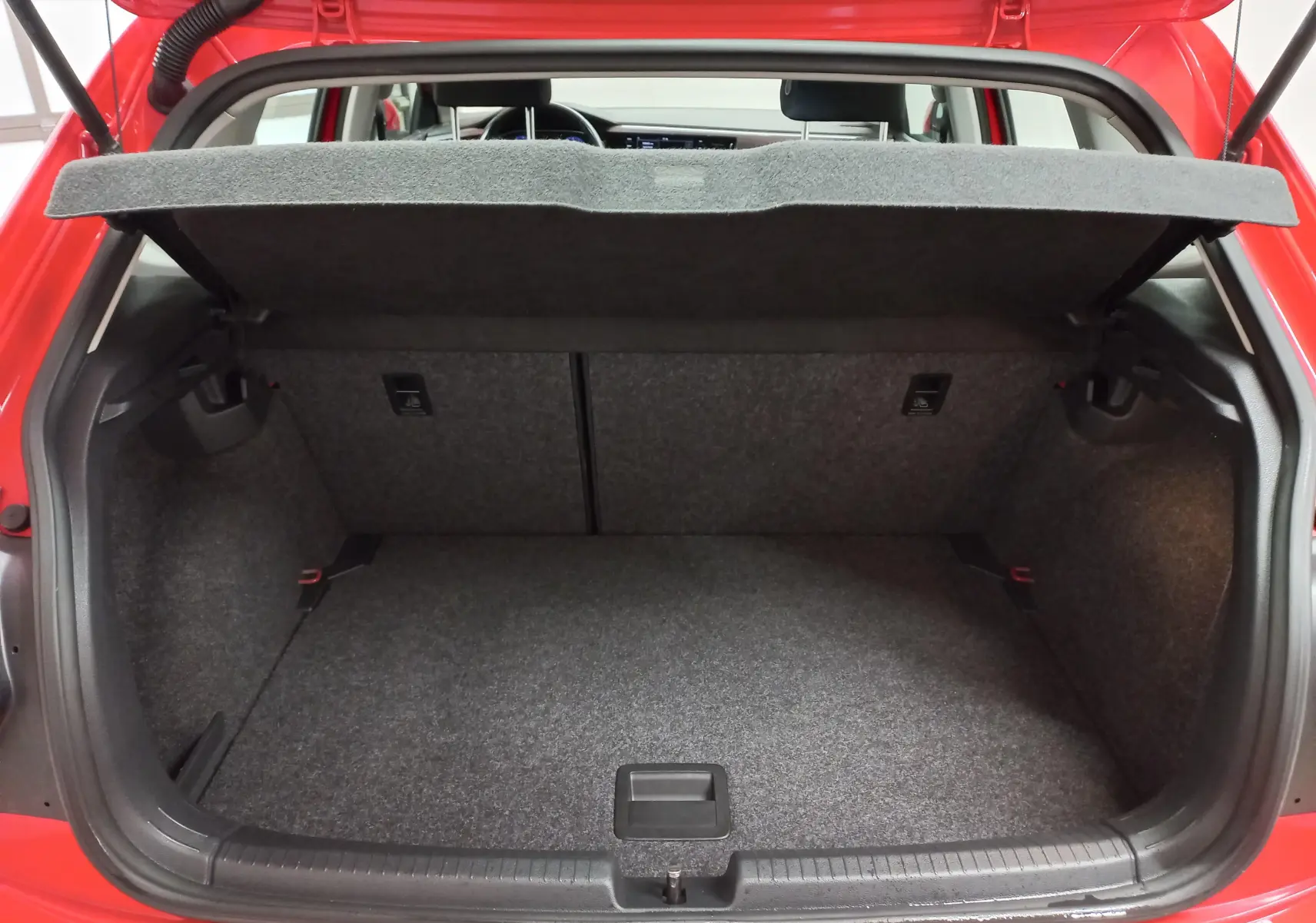 Coffre ouvert vu de l'arrière d'une Volkswagen Polo Rouge Flash 2019, intérieur du coffre en tissu gris.