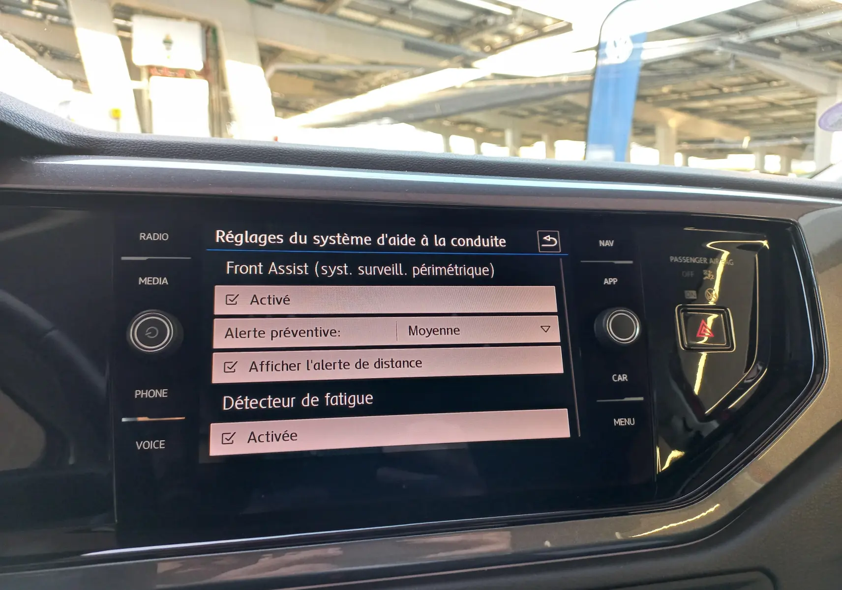 Écran central tactile de la Volkswagen Polo Rouge Flash 2019 affichant les réglages d'aide à la conduite et détecteur de fatigue activés.