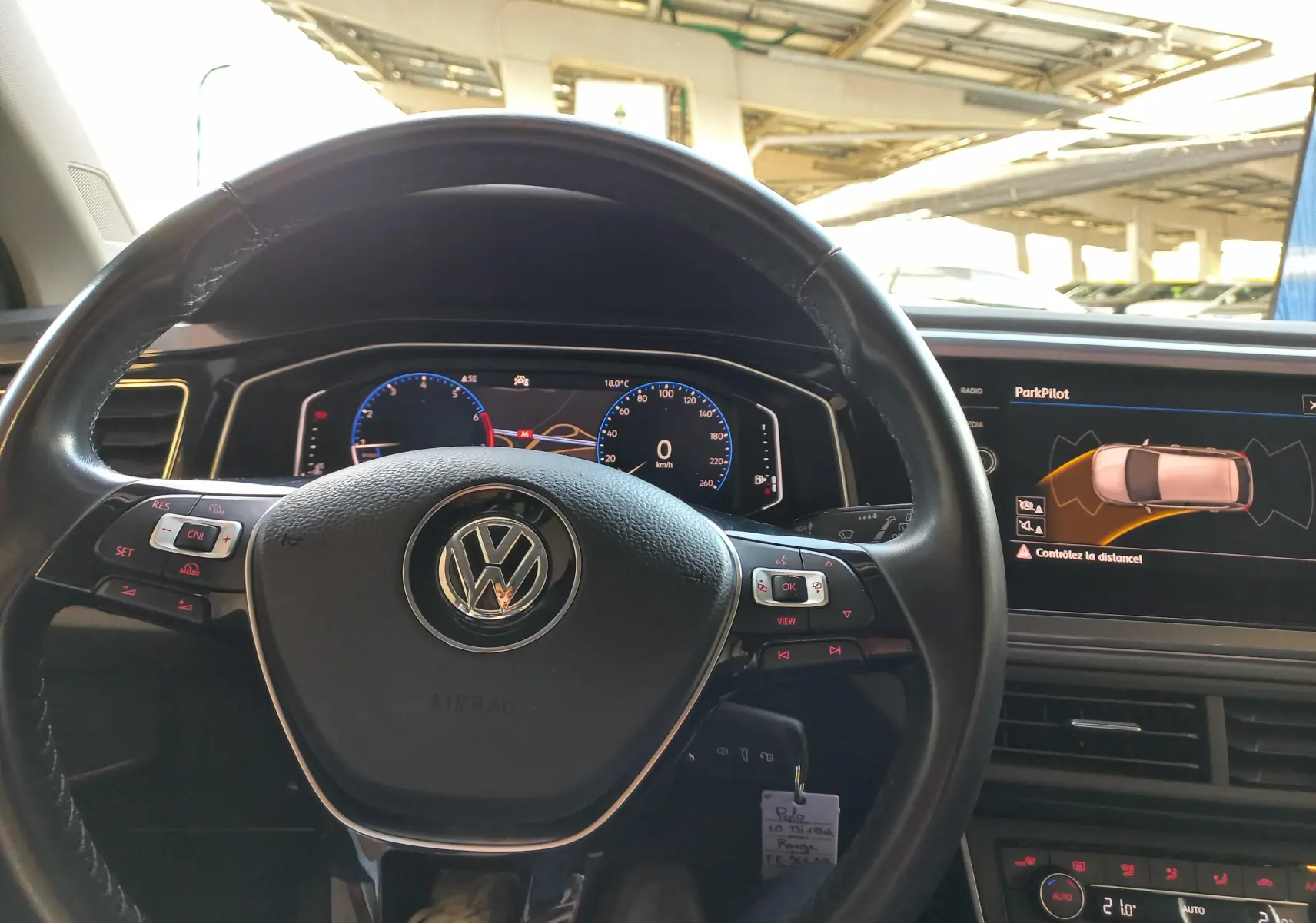 Vue intérieure centrée sur le volant Volkswagen Polo Rouge Flash 2019 avec affichage numérique et écran ParkPilot.