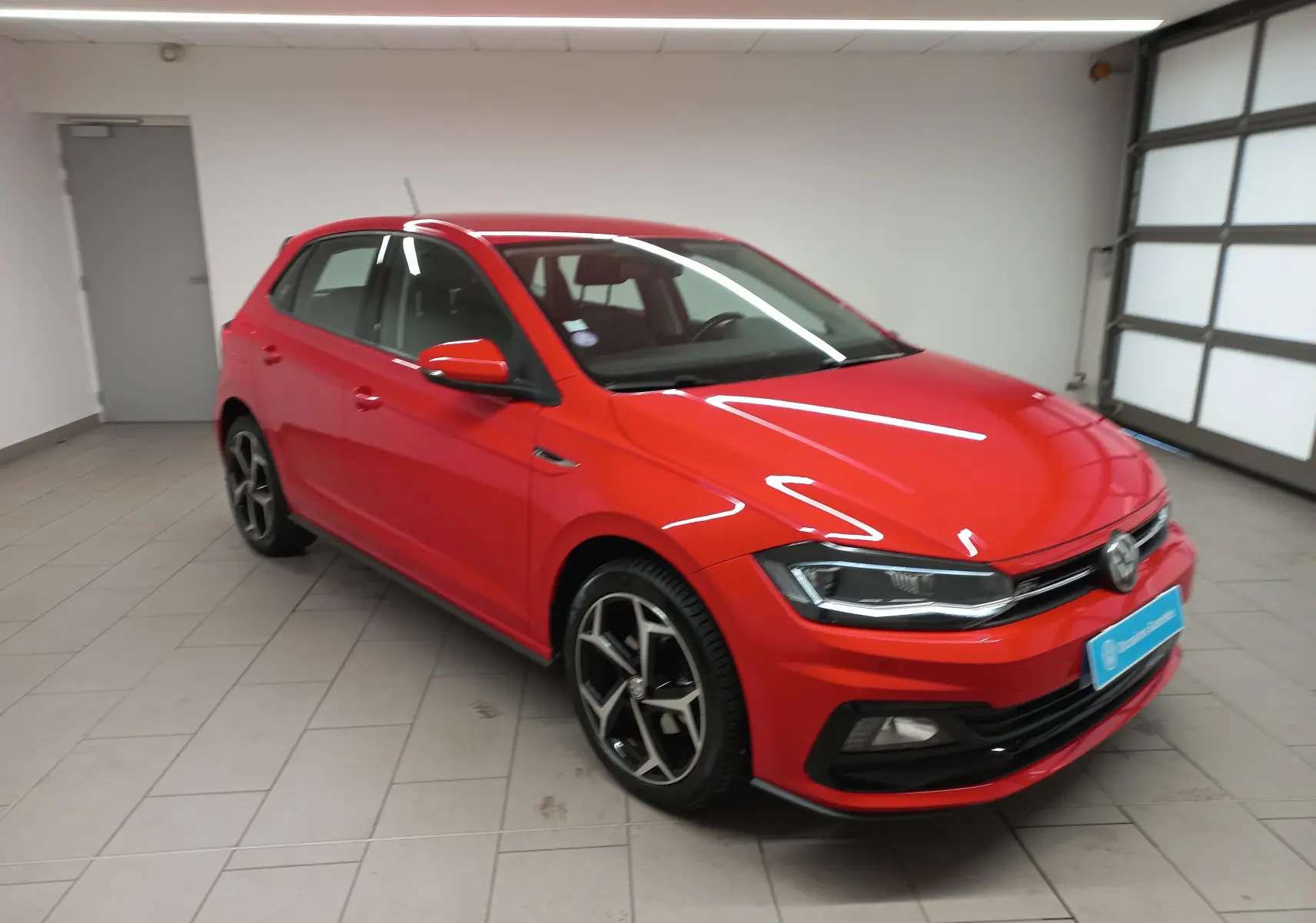 Volkswagen Polo Rouge Flash 2019 en vue 3/4 avant droit, avec jantes R-Line et phares LED distinctifs.