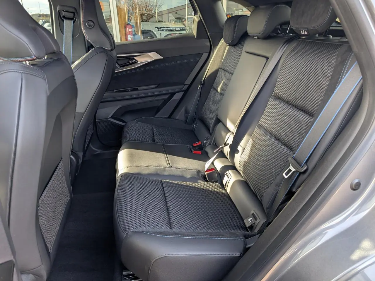 Vue latérale droite de la banquette arrière noire avec surpiqûres bleues du Renault Austral 2025 gris métallisé Esprit Alpine.