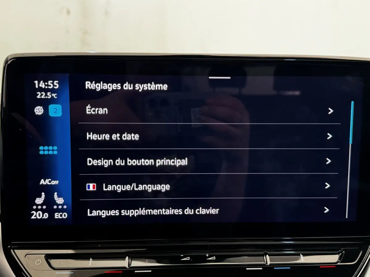 Écran tactile central affichant les réglages système dans un Volkswagen ID.4 blanc, vue intérieure frontale.