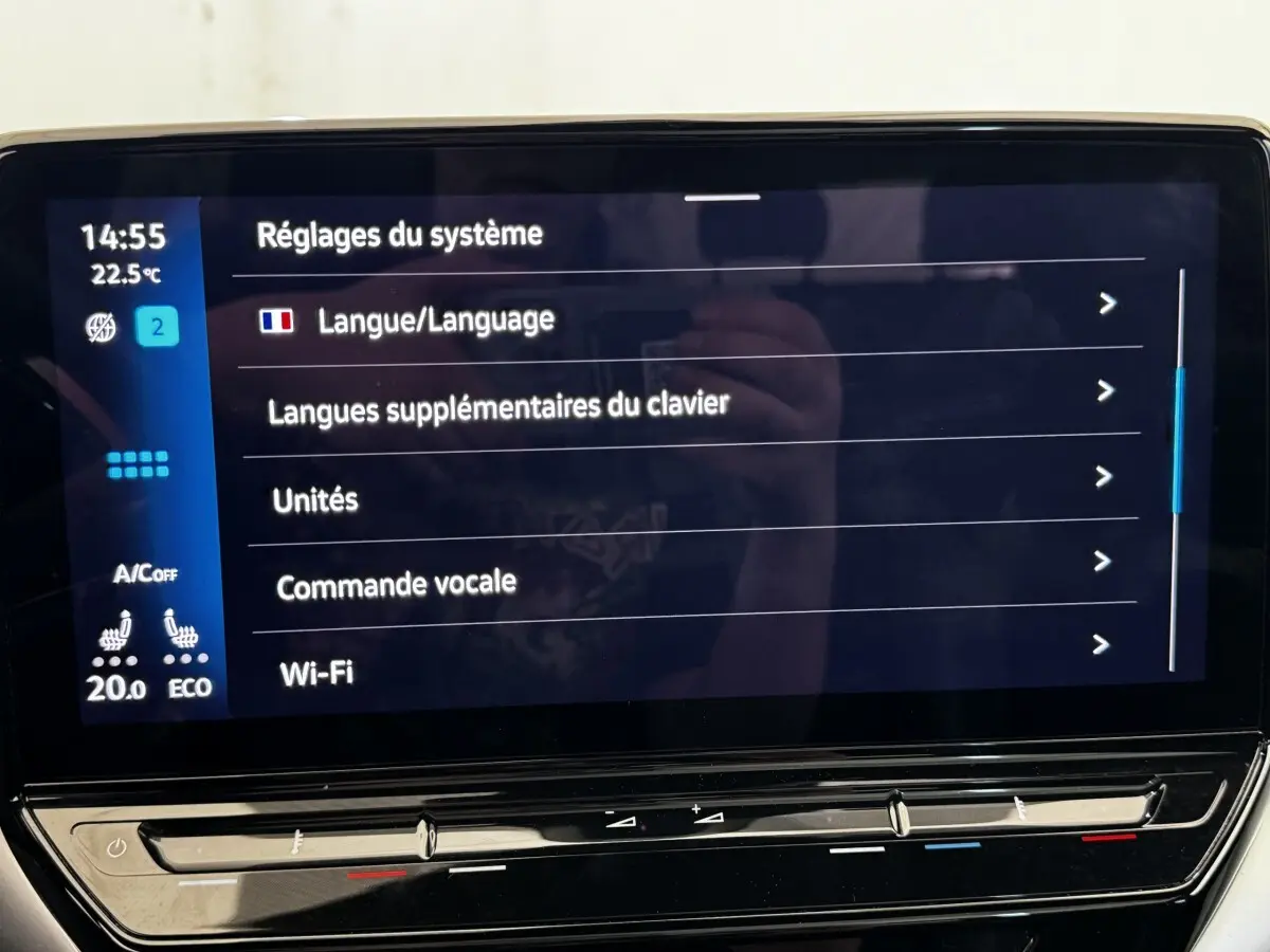 Écran tactile central du Volkswagen ID.4 blanc, affichant les réglages système en intérieur.