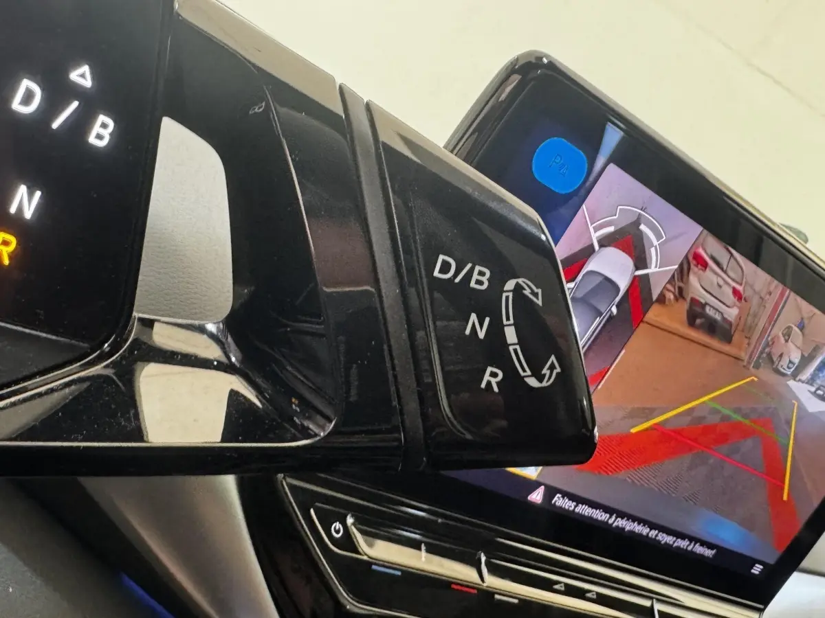 Gros plan intérieur sur le levier de vitesses et l'écran tactile affichant la caméra de recul du Volkswagen ID.4 blanc.