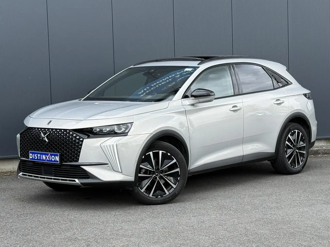 DS7 2025 Cristal Pearl en 3/4 avant droit, avec calandre noire distinctive et jantes alliage noires et argentées.