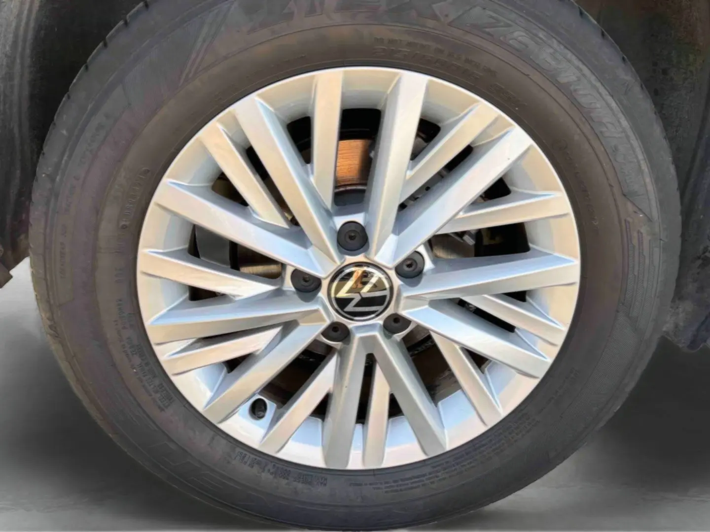 Gros plan sur la jante en alliage léger 16'' Chester argentée du Volkswagen T-Roc noir, avec logo VW central visible.