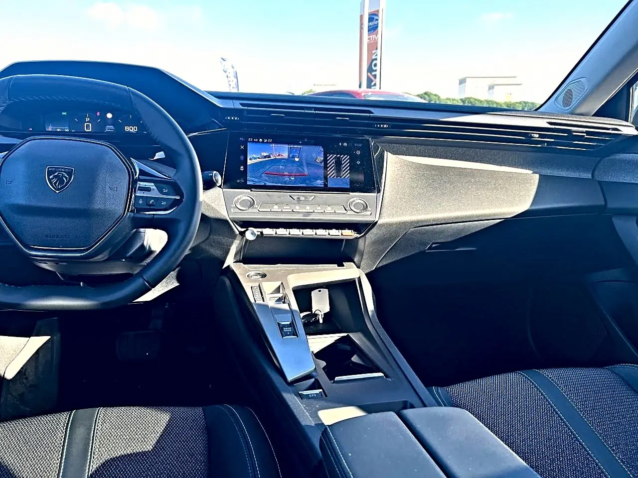 Vue intérieure avant de la Peugeot 308 1.5 BlueHDi 130 allure, tableau de bord et écran tactile central visibles.
