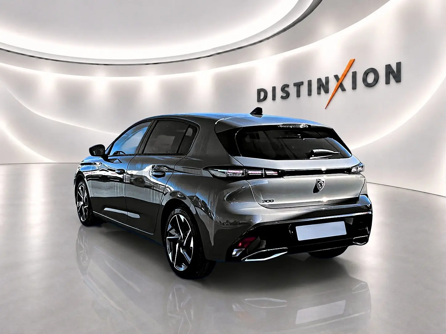 Peugeot 308 gris selenium vue 3/4 arrière droit en intérieur avec jantes alu et feux arrière LED distinctifs.