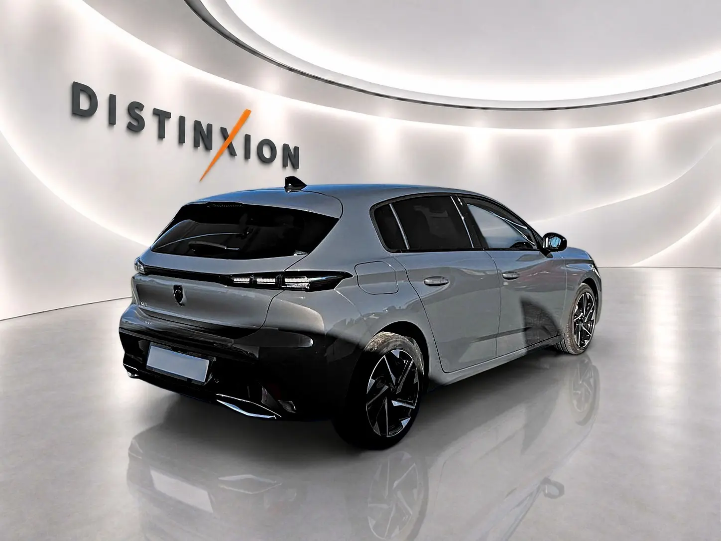 Peugeot 308 gris selenium vue 3/4 arrière droit en intérieur, vitres arrière surteintées et jantes alu noires.