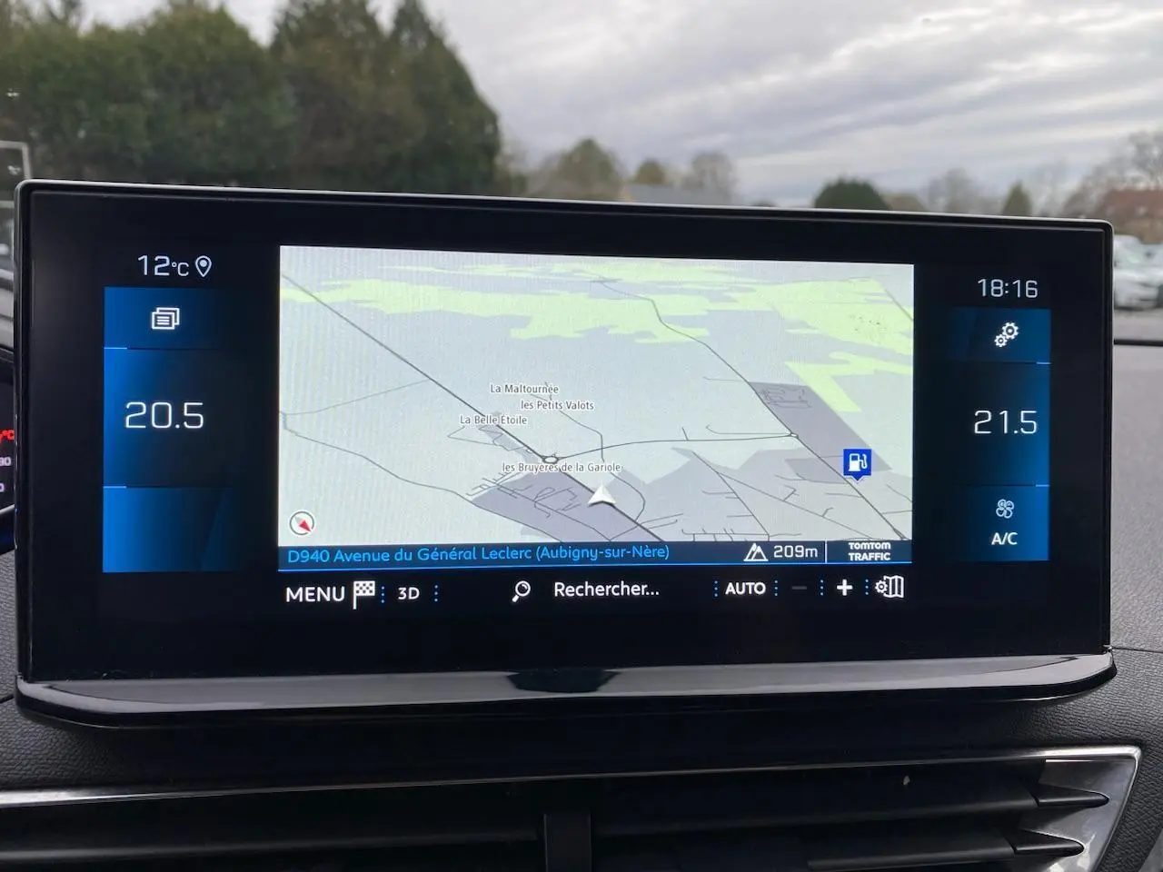 Écran tactile 10 pouces du GPS Peugeot i-Cockpit affichant une carte avec température et réglages climatisation.