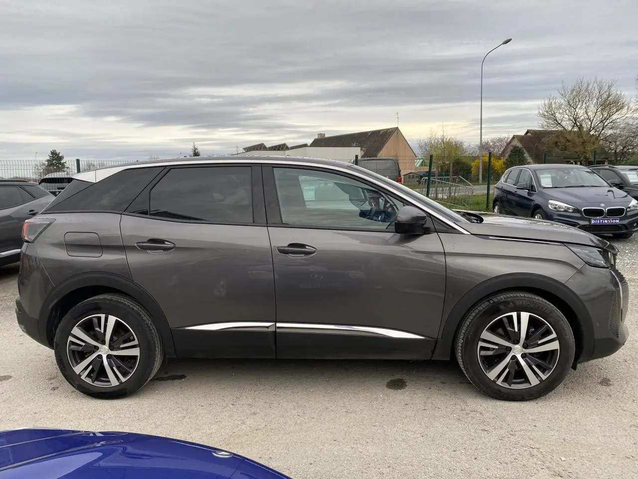 Profil côté gauche du Peugeot 3008 gris platinium 2021, soulignant ses lignes modernes et ses jantes alliage bicolores.