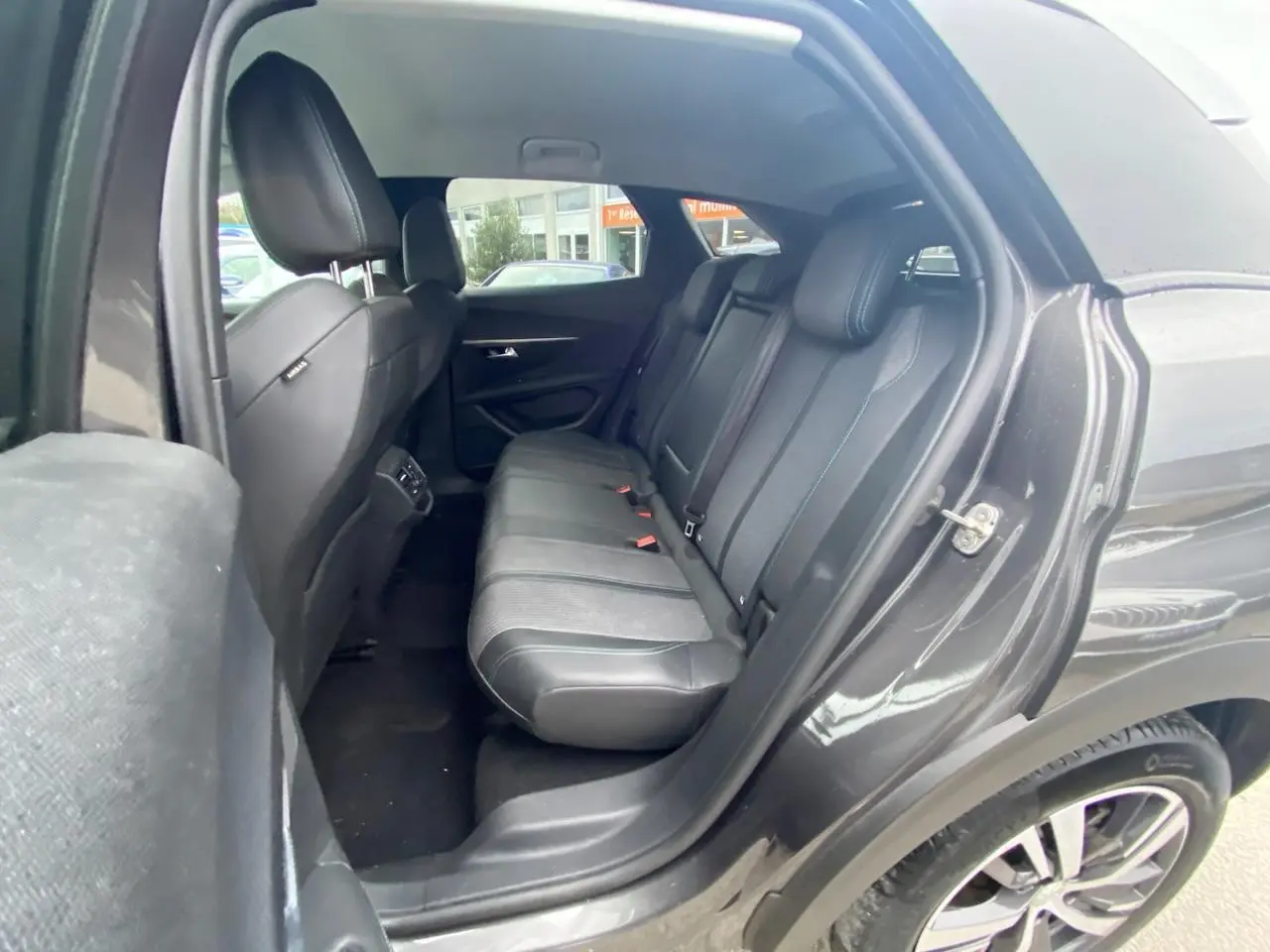 Vue côté droit arrière du Peugeot 3008 gris platinium 2021, montrant la banquette arrière en cuir noir et tissu.