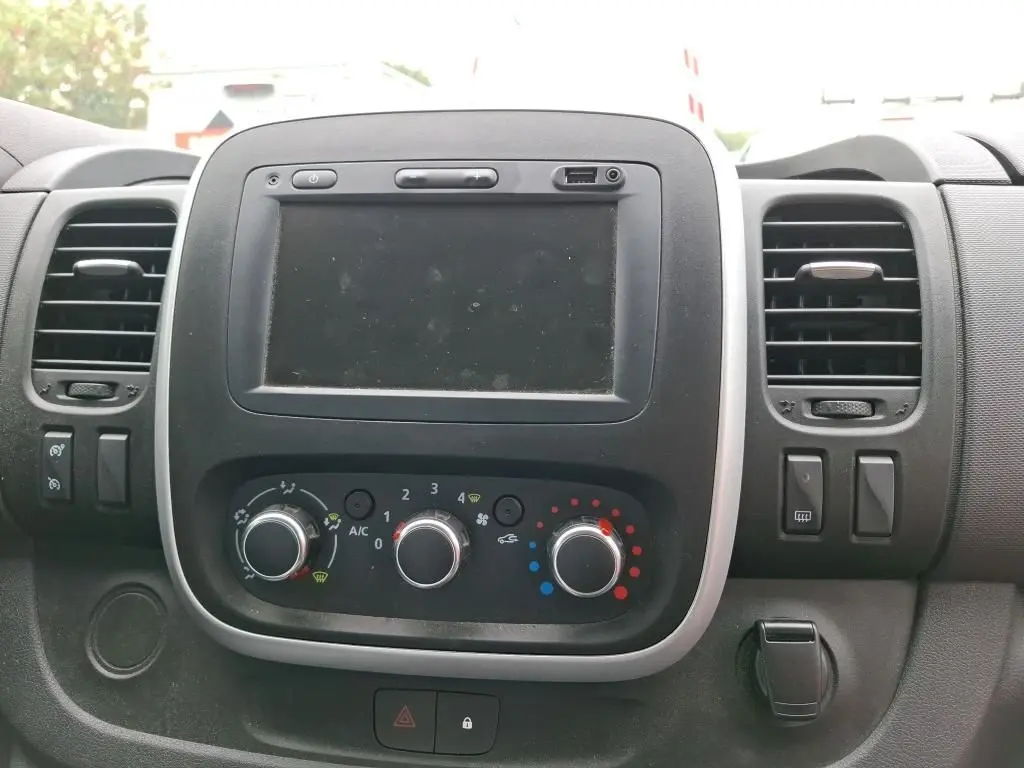 Tableau de bord du Renault Trafic Fourgon blanc 2021, vue frontale centrée sur l'écran tactile et les commandes de climatisation.