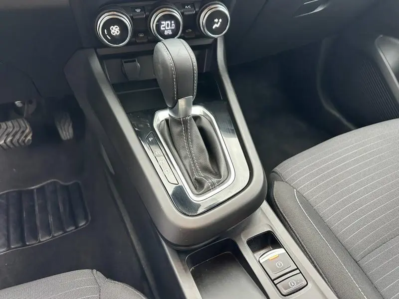 Gros plan sur la console centrale du Renault Arkana 2025, montrant le levier de vitesses automatique et les commandes de climatisation.