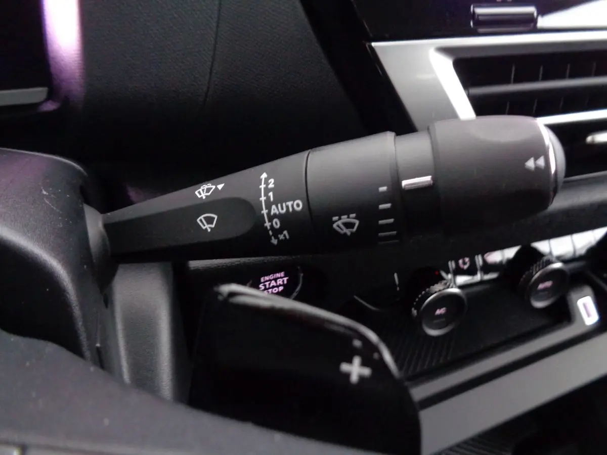 Gros plan sur la commande d'essuie-glace et le bouton start/stop du tableau de bord d'une Citroën C4 gris Artense 2023.