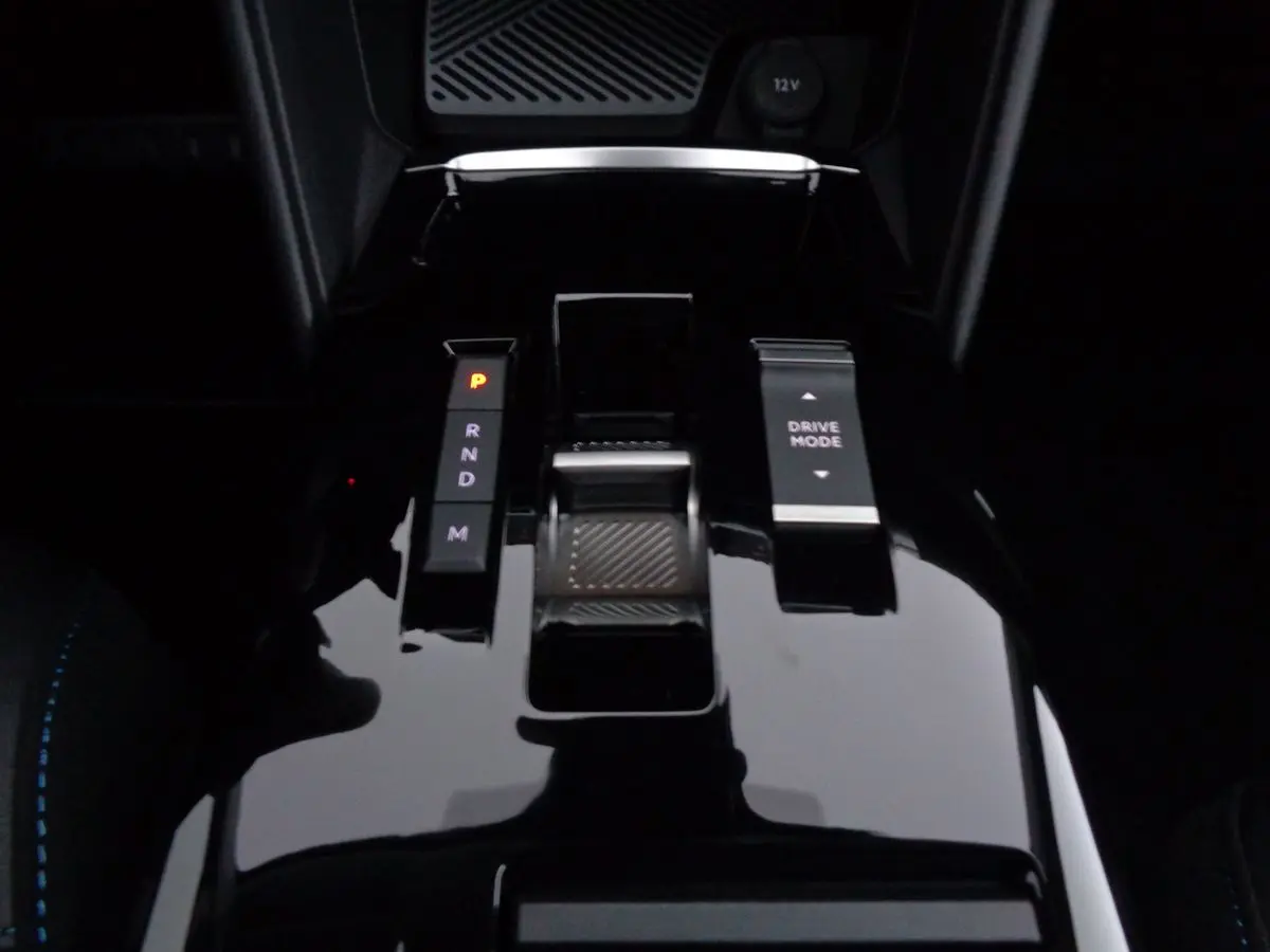 Gros plan sur la console centrale brillante de la Citroën C4 gris Artense, avec levier de vitesses automatique et bouton Drive Mode.