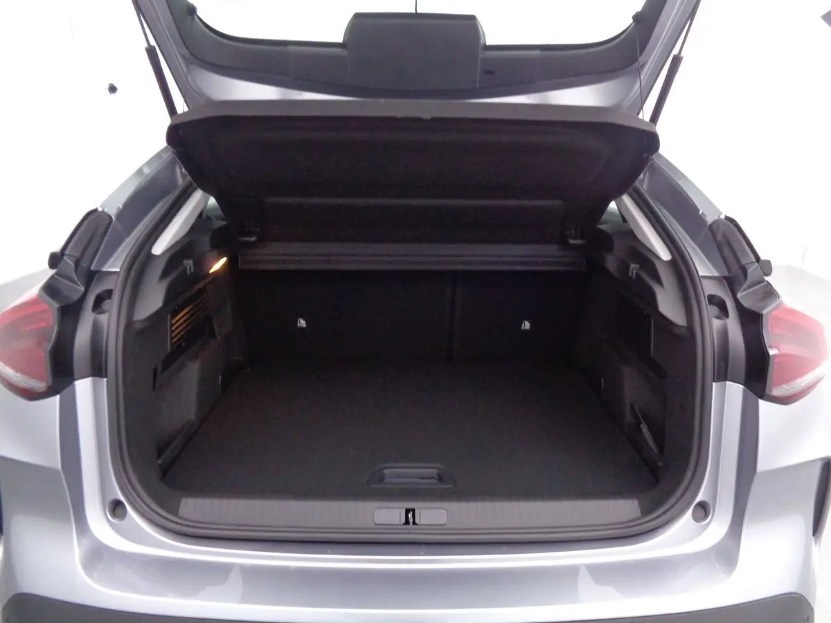 Coffre ouvert vu de l'arrière d'une Citroën C4 2023 gris Artense métal, montrant un espace de chargement spacieux.
