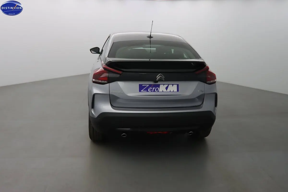 Vue arrière d'une Citroën C4 gris Artense métal 2023 avec double sortie d'échappement et hayon noir contrasté.