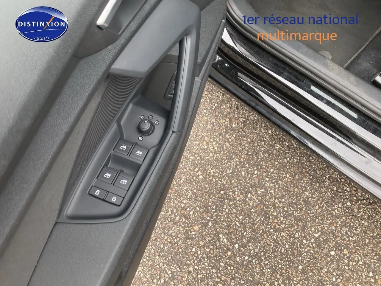 Vue rapprochée de la commande des vitres électriques sur la portière côté gauche d'une Audi A3 Sportback noire.