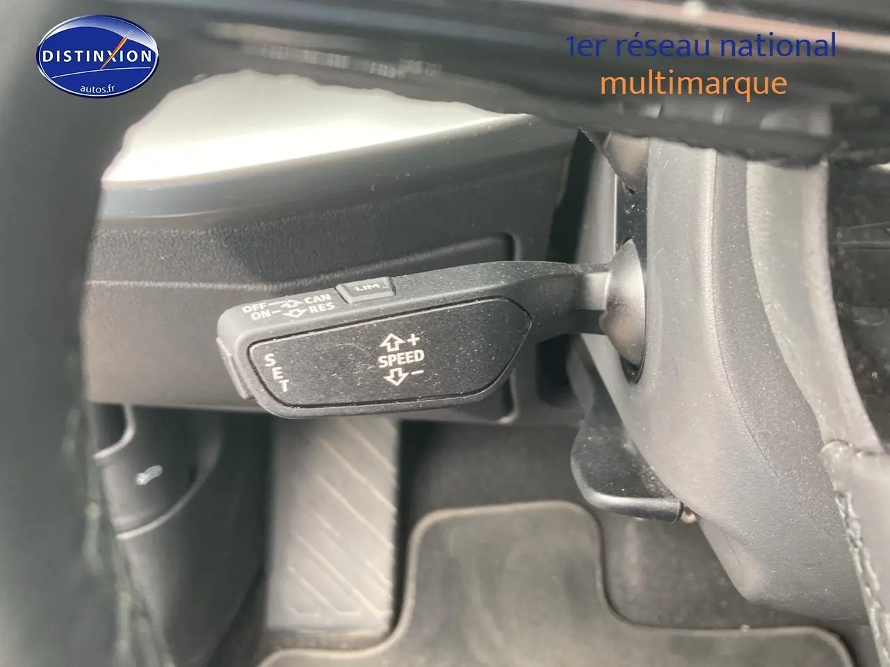 Gros plan sur la commande de régulateur de vitesse côté gauche dans l'habitacle noir de l'Audi A3 Sportback 2021.