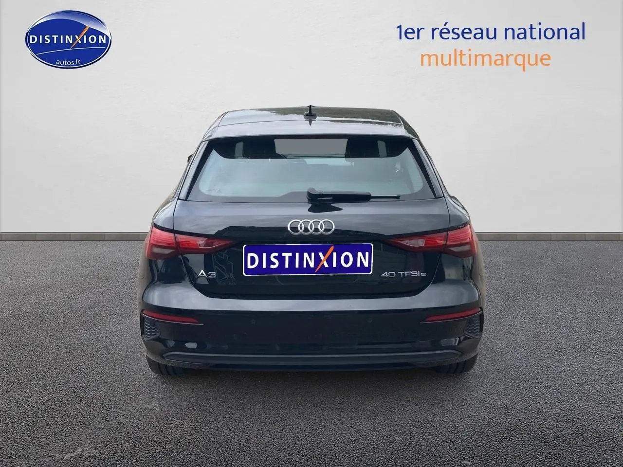 Vue arrière d'une Audi A3 Sportback 40 TFSI noire stationnée, avec logo et feux arrière visibles.