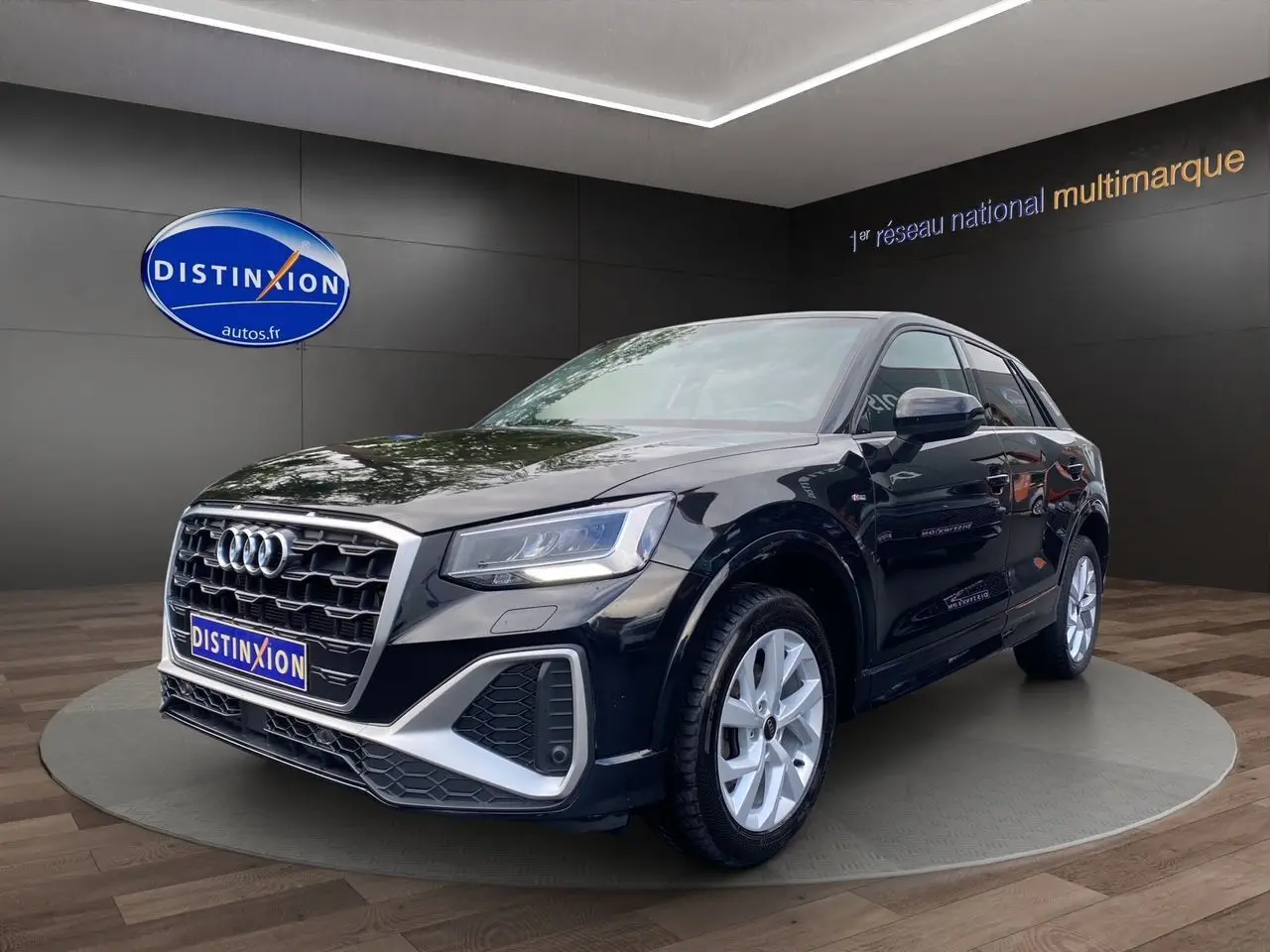 Audi Q2 noir mito en 3/4 avant droit, avec calandre S-Line et jantes alliage 17 pouces visibles en showroom