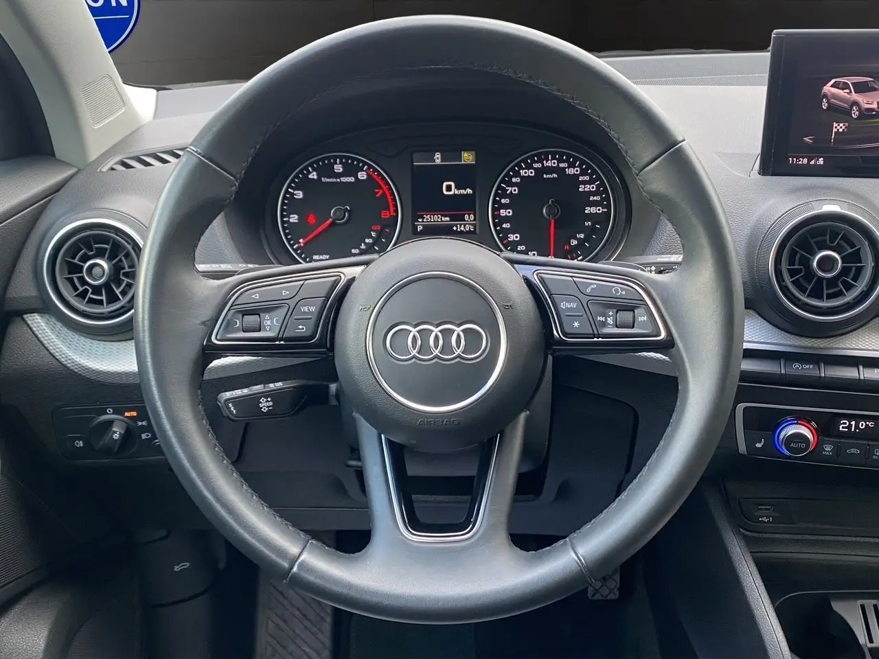 Vue centrée sur le volant noir de l'Audi Q2 2023 avec tableau de bord digital et commandes multifonctions visibles