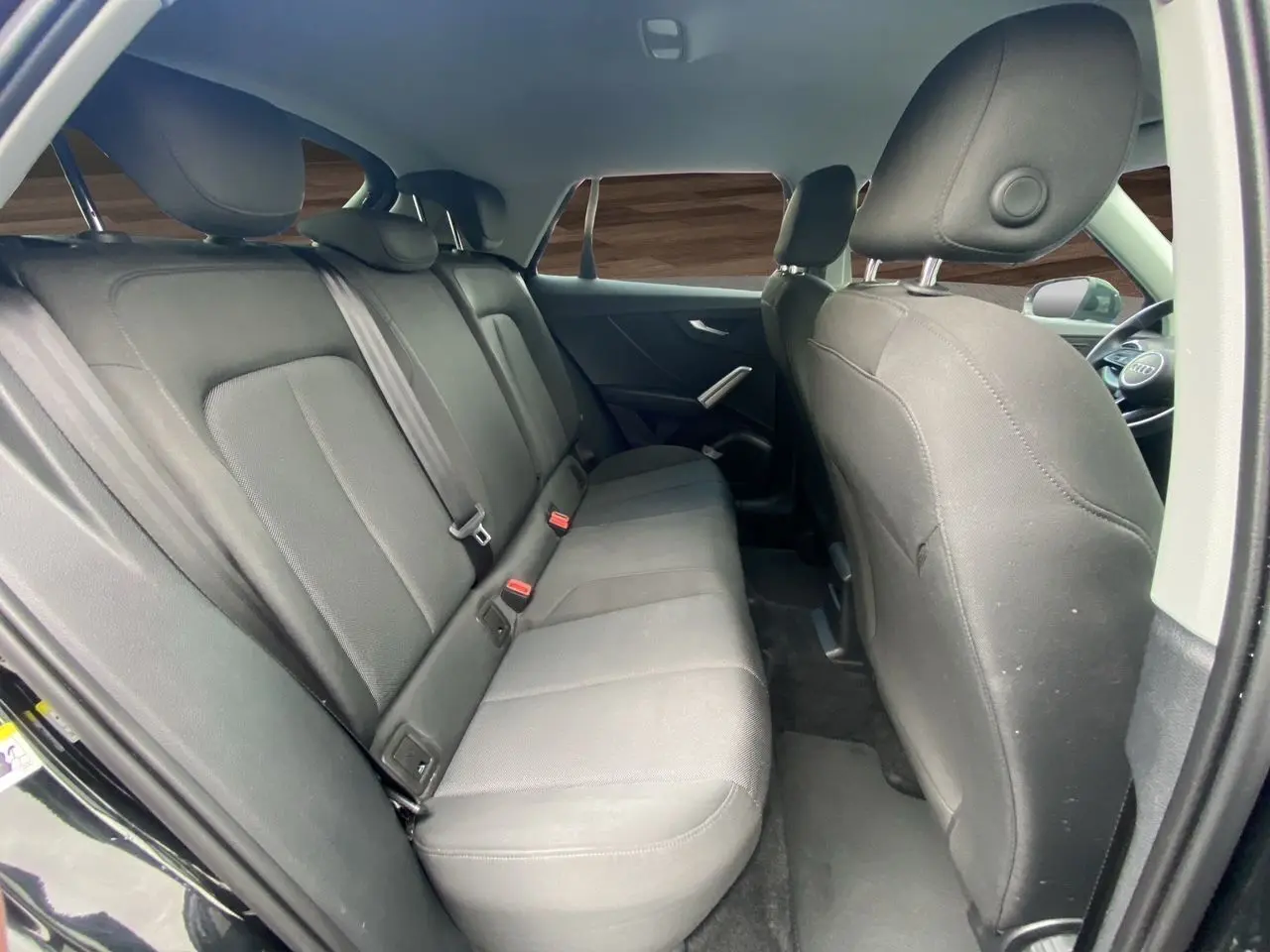 Vue intérieure arrière côté droit des sièges en tissu noir du SUV Audi Q2 noir Mito 2023.