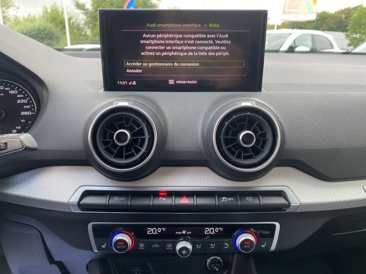 Tableau de bord de l'Audi Q2 noir Mito 2023, vue frontale centrée sur l'écran MMI et les aérateurs ronds.