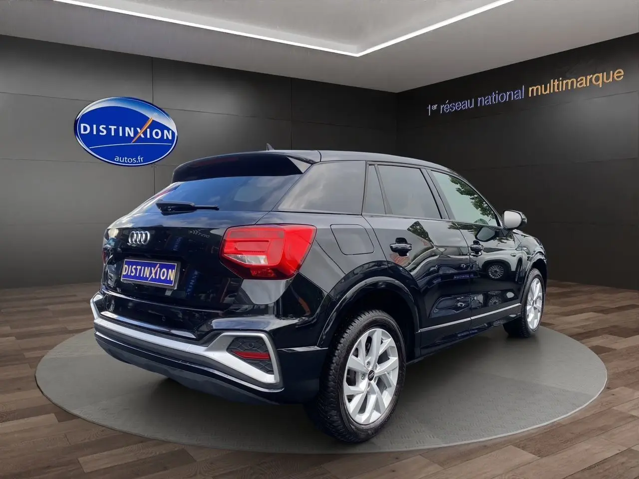 Audi Q2 noir mito vue 3/4 arrière droit, jantes alliage 17 pouces et hayon motorisé visible en showroom