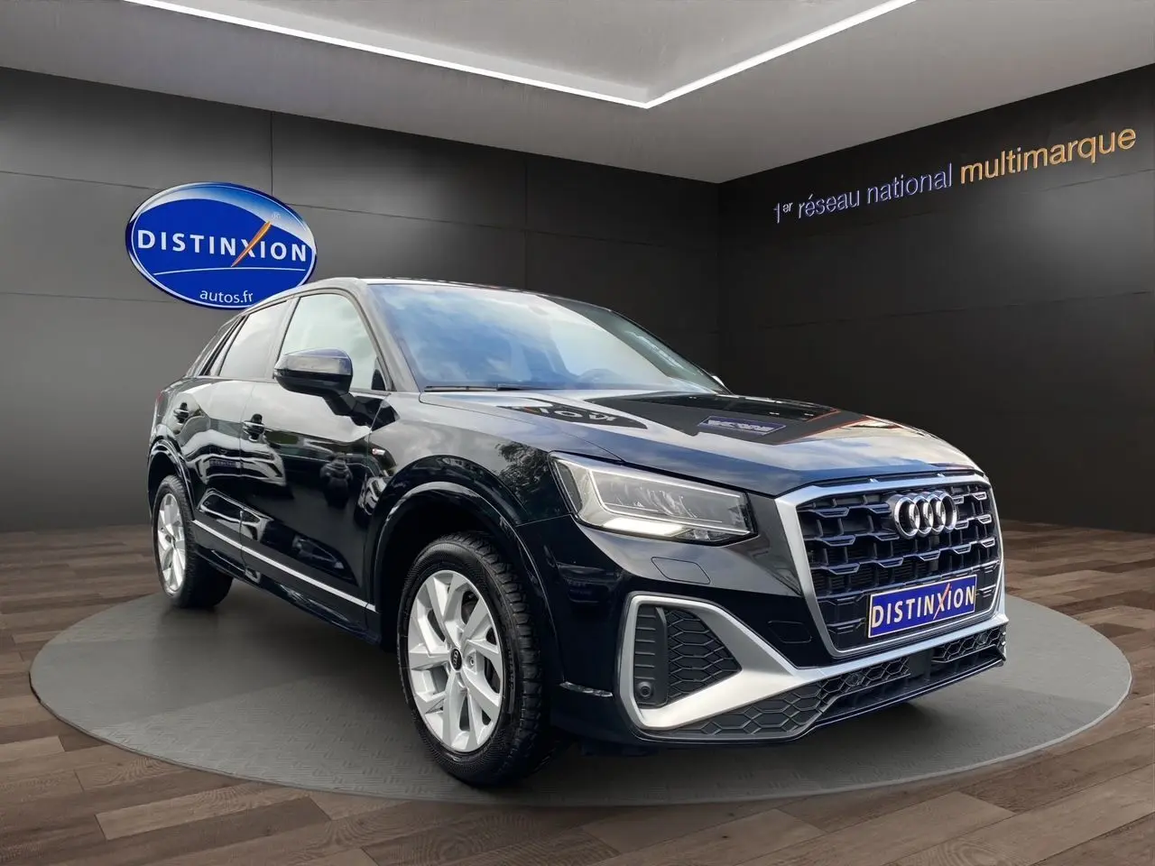 Audi Q2 noir mito en 3/4 avant droit, mettant en valeur sa calandre hexagonale et ses jantes alliage 17 pouces.