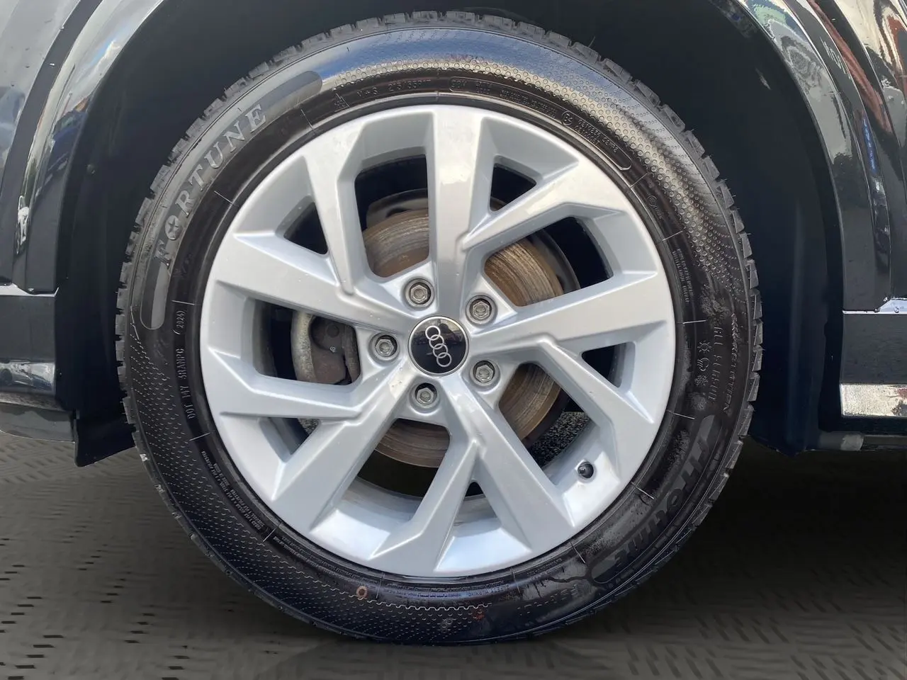 Gros plan sur la jante alliage 7x17 argentée du côté gauche d'un Audi Q2 noir Mito 2023.