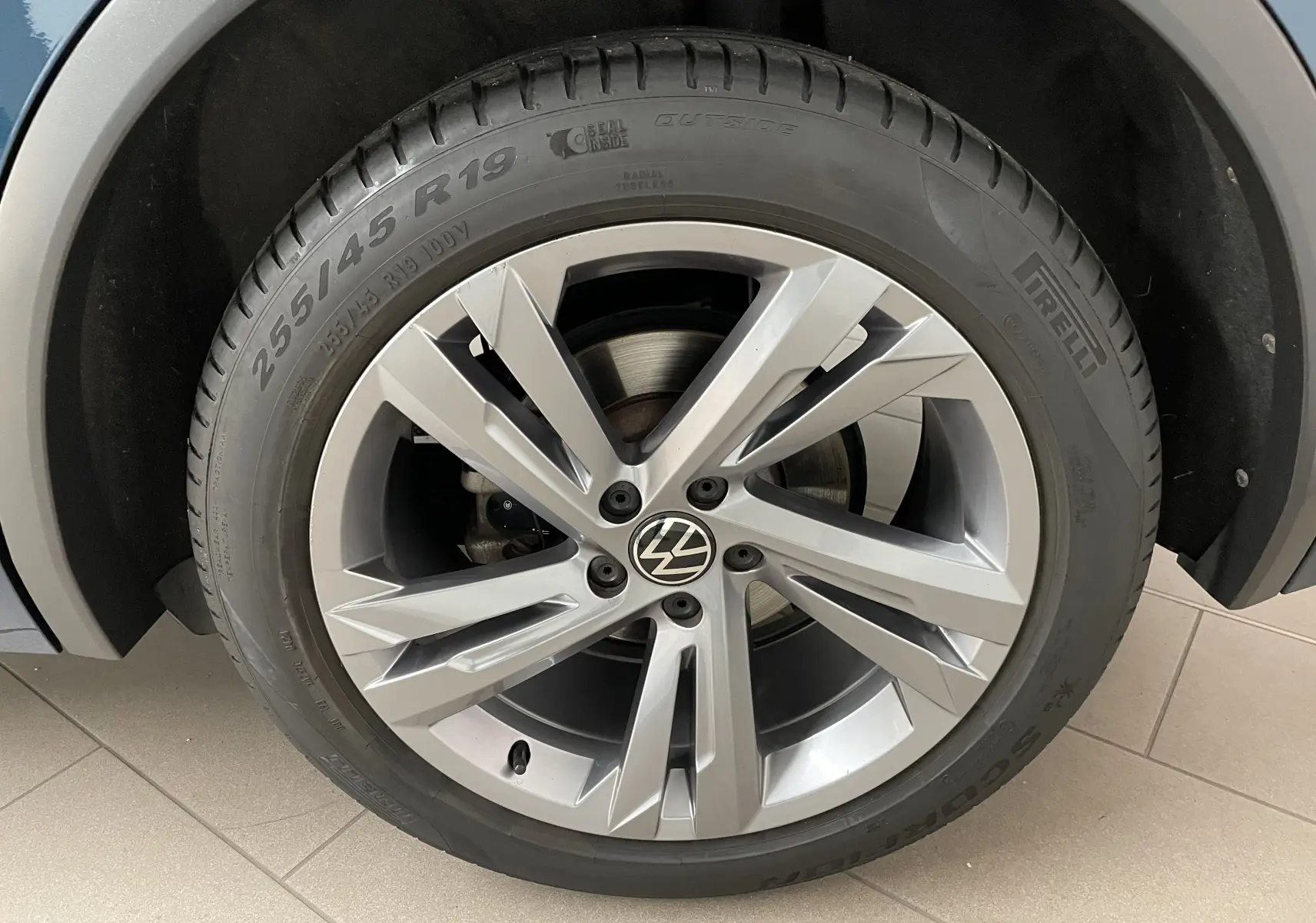 Gros plan sur la jante alliage 19 pouces du Volkswagen Tiguan Nightshade Blue 2024 avec pneu Pirelli.