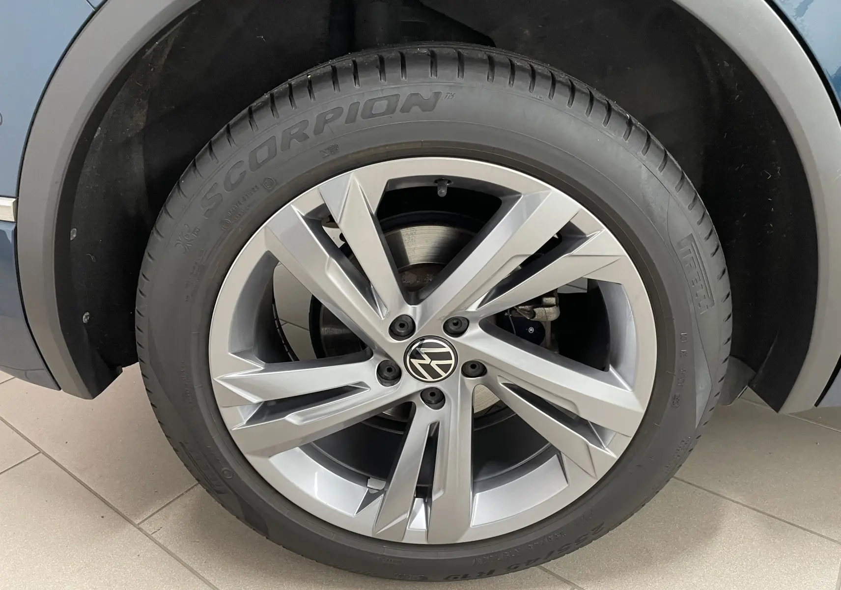 Gros plan sur la roue avant droite du Volkswagen Tiguan 2024 Nightshade Blue avec jante alliage et pneu Pirelli Scorpion.