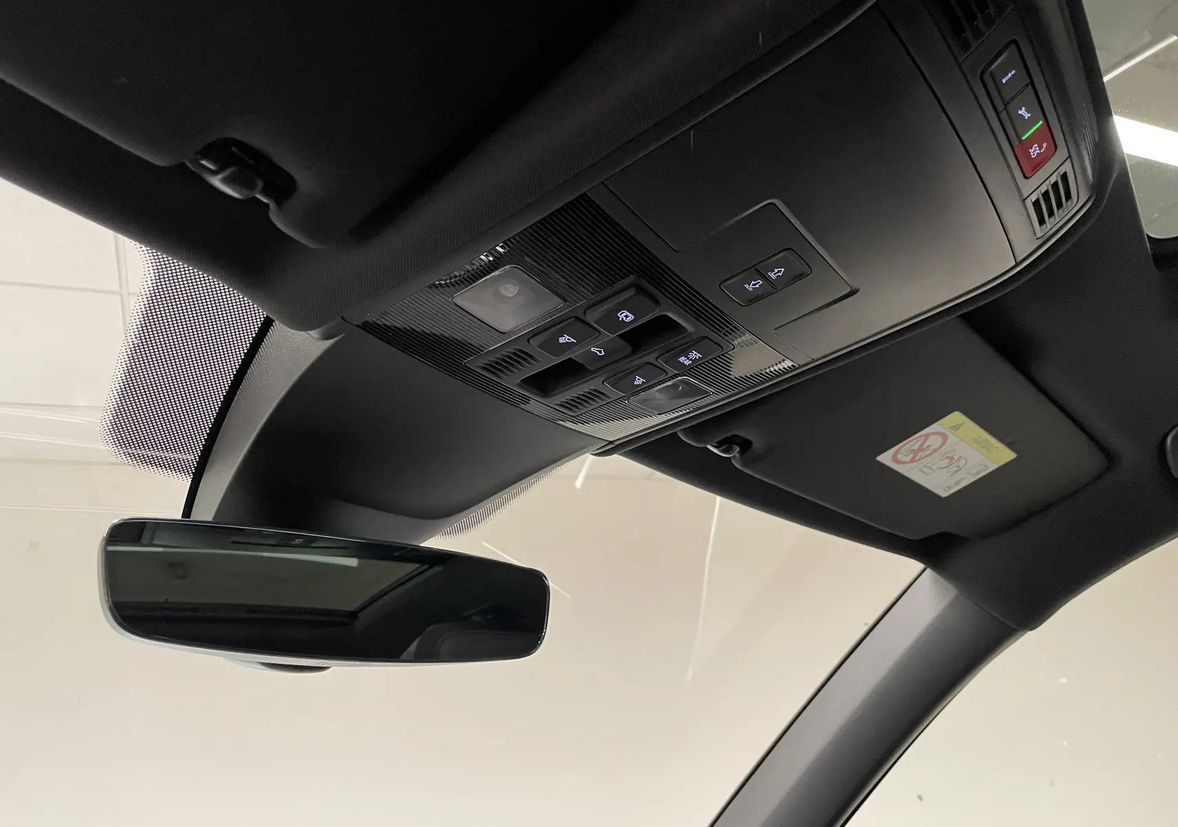 Vue intérieure du toit et du plafonnier du Volkswagen Tiguan 2024, avec commandes lumineuses et rétroviseur central.