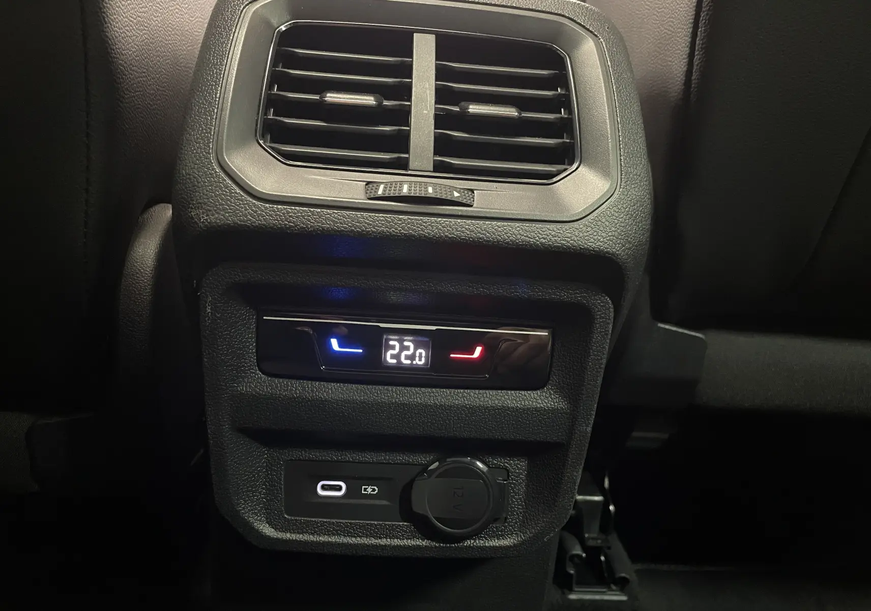 Détail de la console arrière du Volkswagen Tiguan 2024 avec réglage de la climatisation et prises USB et 12V.