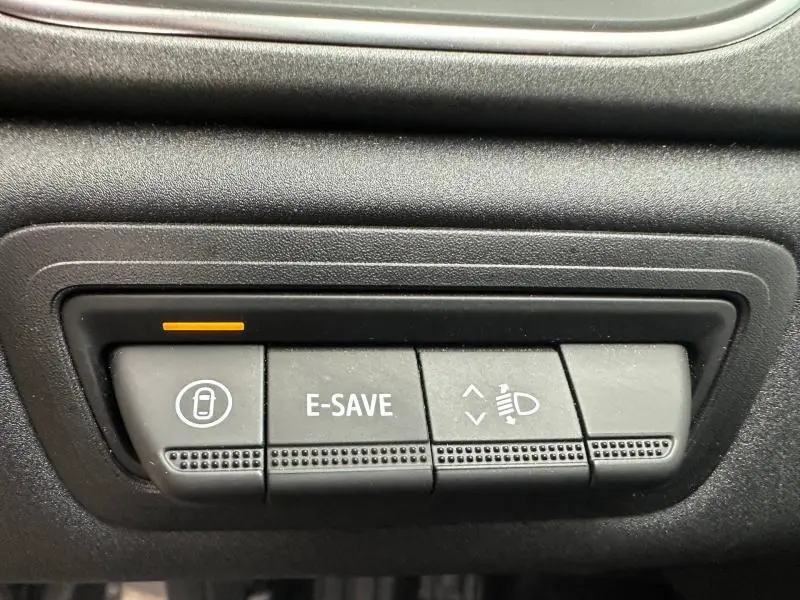 Gros plan sur les boutons de commande intérieurs du Renault Captur noir 2025, avec fonction E-SAVE et réglage des phares.