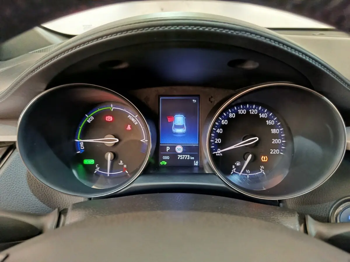 Vue rapprochée du tableau de bord du Toyota C-HR hybride 2022, affichage numérique et compteurs analogiques.